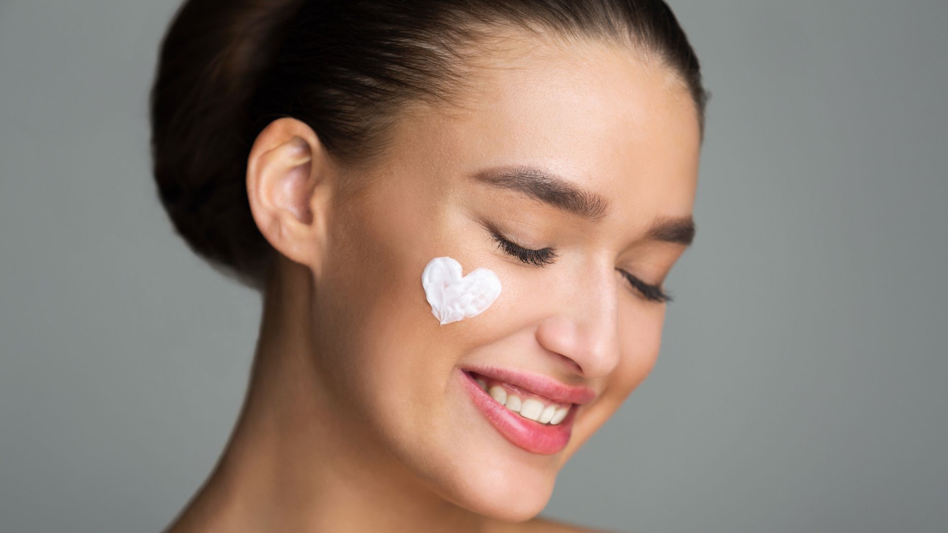 Photo of a heart-shaped cream spot on a woman's face, symbolizing skincare and beauty treatment at Agigma Holistic Spa